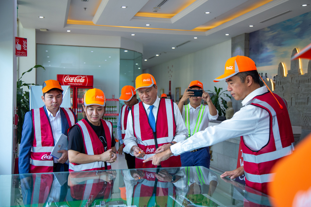 柬埔寨可口可乐首席执行官何蔚堃(右)向访问团介绍装瓶厂内的运作及设施。